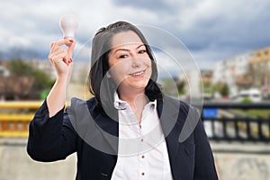 Happy businesswoman holding lightbulb as good idea concept