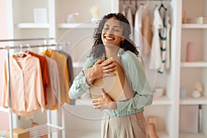 Happy businesswoman hugging a package in her office