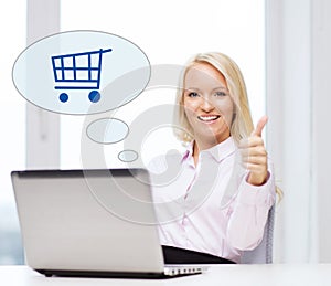 Happy businesswoman with laptop showing thumbs up