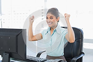 Happy businesswoman looking at computer in office