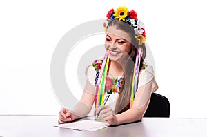 Happy businesswoman with note and pen by a desk.In the Ukrainian
