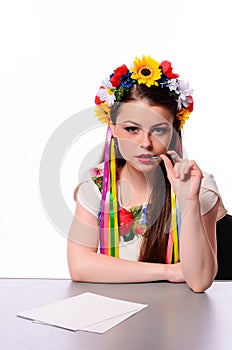 Happy businesswoman with note and pen by a desk.In the Ukrainian national costume