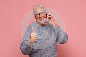 Happy businesswoman with phone and thumbs up gesture