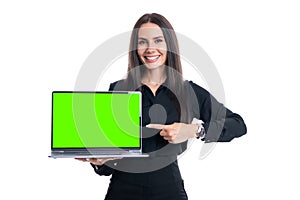 Happy businesswoman pointing at open laptop computer with green screen chroma key effect mockup