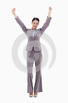 A happy businesswoman posing with the arms up