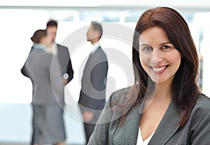 Happy businesswoman posing while her team talking