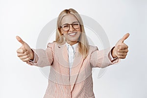 Happy businesswoman reaching hands, stretching arms out to congratulate you, praising good work with hug, standing over