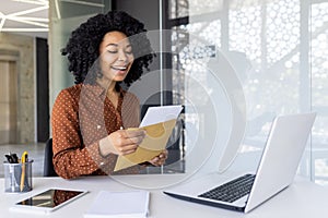 Happy businesswoman reading a letter at stylish modern office