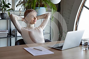 Happy businesswoman relax at workplace making plans