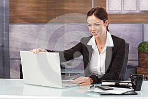 Happy businesswoman shutting down laptop photo