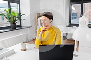 Happy businesswoman sitting at office table