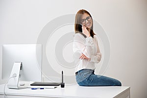 Happy businesswoman sitting on the table