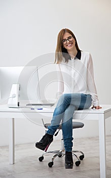 Happy businesswoman sitting on the table