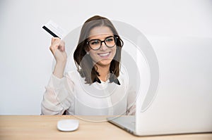 Happy businesswoman sitting at the table with laptop