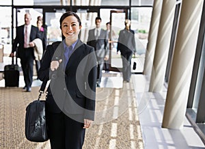 Happy businesswoman in suit holding briefcase