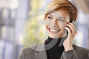 Happy businesswoman talking on mobile outdoors