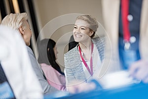 Happy businesswoman talking to colleague at lobby in convention center