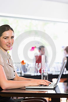 Happy businesswoman typing on laptop