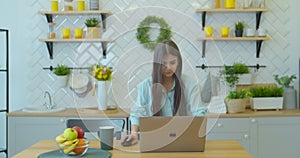 Happy businesswoman using laptop computer at home office in slow motion. Cheerful woman working laptop at table on