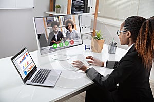 Happy Businesswoman Videoconferencing With Her Colleagues