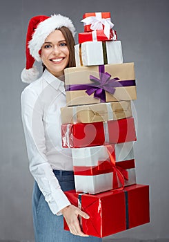 Happy businesswoman wearing Santa hat holding heap of christmas