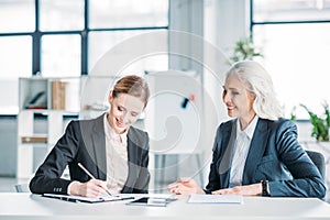 Happy businesswomen discussing business project on meeting in office