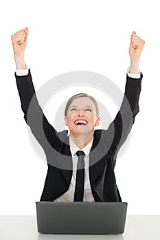 Happy businesswomen with laptop, hands up