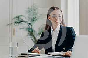 Happy bussiness woman working on laptop at office