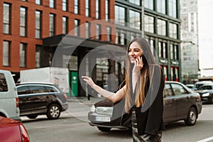 Happy busy businesswoman in casual clothes talking on the phone and catches a hand gesture. Smiling formal-dressed lady