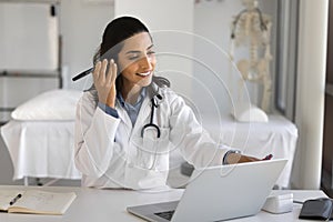 Happy busy young doctor woman using digital technology for communication
