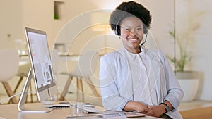 Happy call center agent or customer service and support worker wearing a headset and working in a modern office