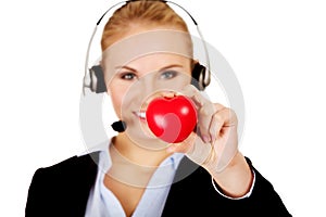 Happy call center woman holding heart toy