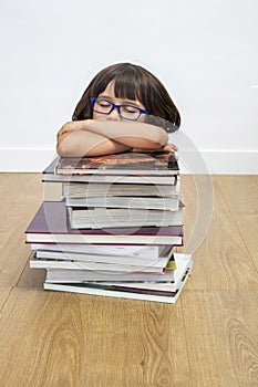 Happy calm gifted child sleeping, lying on pile of books