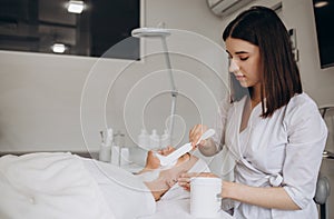 Happy calm relaxed young woman or teenage girl lying on soft towel in beauty parlor or spa salon