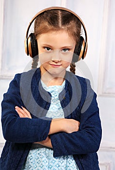 Happy calm serious kid girl in blue jacket listening the music i