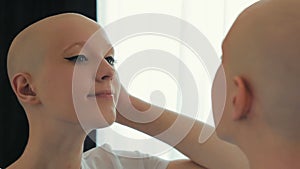 Happy cancer woman survivor looking at herself in the mirror