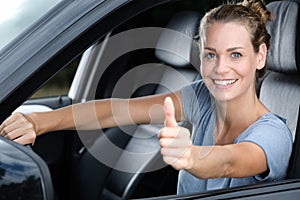 happy car owner looking at camera showing thumbs up