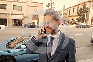 happy car rent dealer speaking on phone outdoor