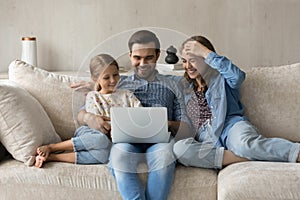 Happy carefree family using computer at home.