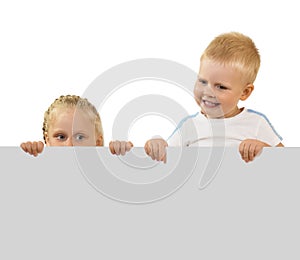 Happy, carefree kids peeking out from behind banner isolated on white