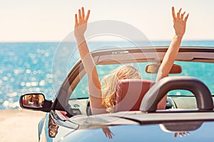 Happy and carefree woman in the car on the beach