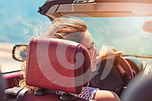 Happy and carefree woman in the car on the beach