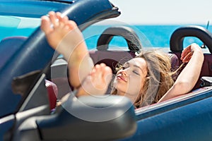 Happy and carefree woman in the car on the beach