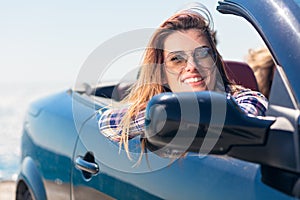 Happy and carefree woman in the car on the beach