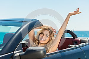 Happy and carefree woman in the car on the beach