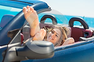 Happy and carefree woman in the car on the beach