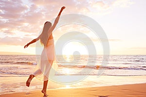 Happy Carefree Woman Dancing on the Beach at Sunset