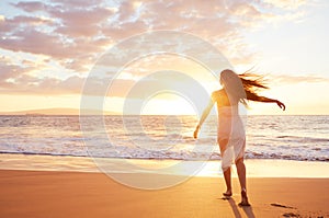 Happy Carefree Woman Dancing on the Beach at Sunset