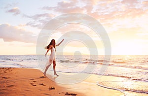 Happy Carefree Woman Dancing on the Beach at Sunset