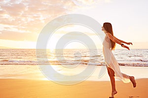 Happy Carefree Woman Dancing on the Beach at Sunset photo